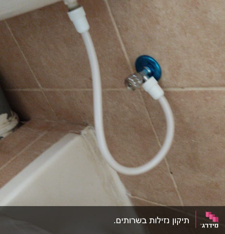 צינור מים מחובר לשסתום בכחול ולבן